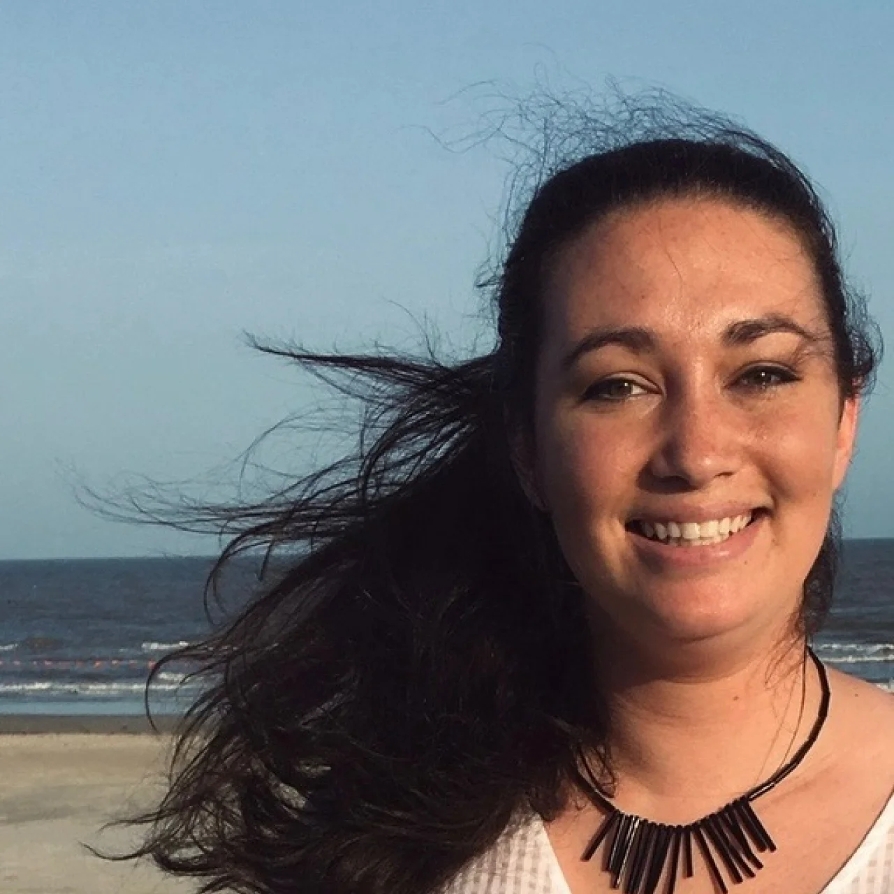 Headshot of Sarah Quint outdoors, smiling.